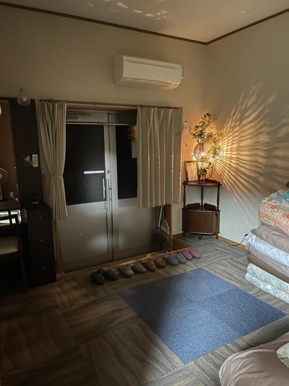 Cette chambre comprend un lit et une porte avec une table. dans l'établissement すずめのお宿 セキレイの間 最大5名 Wagtail Room Maximum of 5 people, à Kotohira