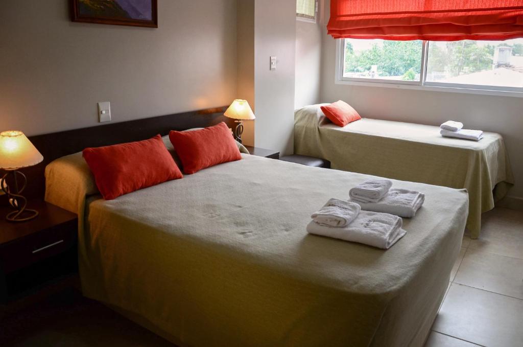Una habitación de hotel con dos camas con toallas. en Munay Ledesma, en Libertador General San Martín