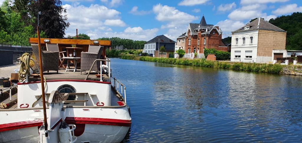 a boat is docked on a river in a town at Péniche Sir Lancelot in Thuin