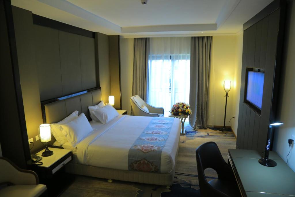 una camera d'albergo con un grande letto e una TV di Check Inn Hotel Addis Ababa ad Addis Abeba