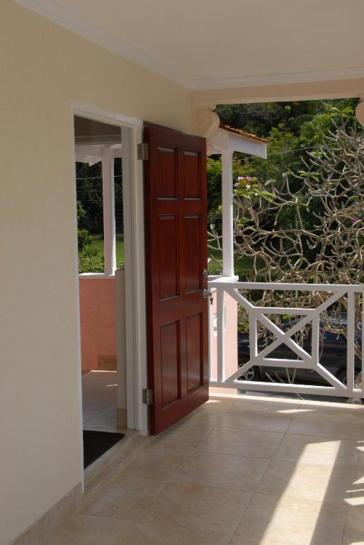 an open door of a house with a balcony at Sandy Bliss Condominiums in Saint James