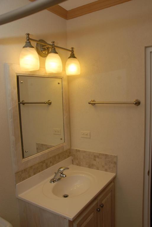 a bathroom with a sink and a mirror at Sandy Bliss Condominiums in Saint James