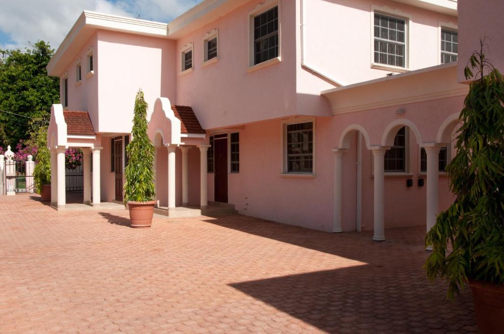 a large white house with a brick driveway at Sandy Bliss Condominiums in Saint James