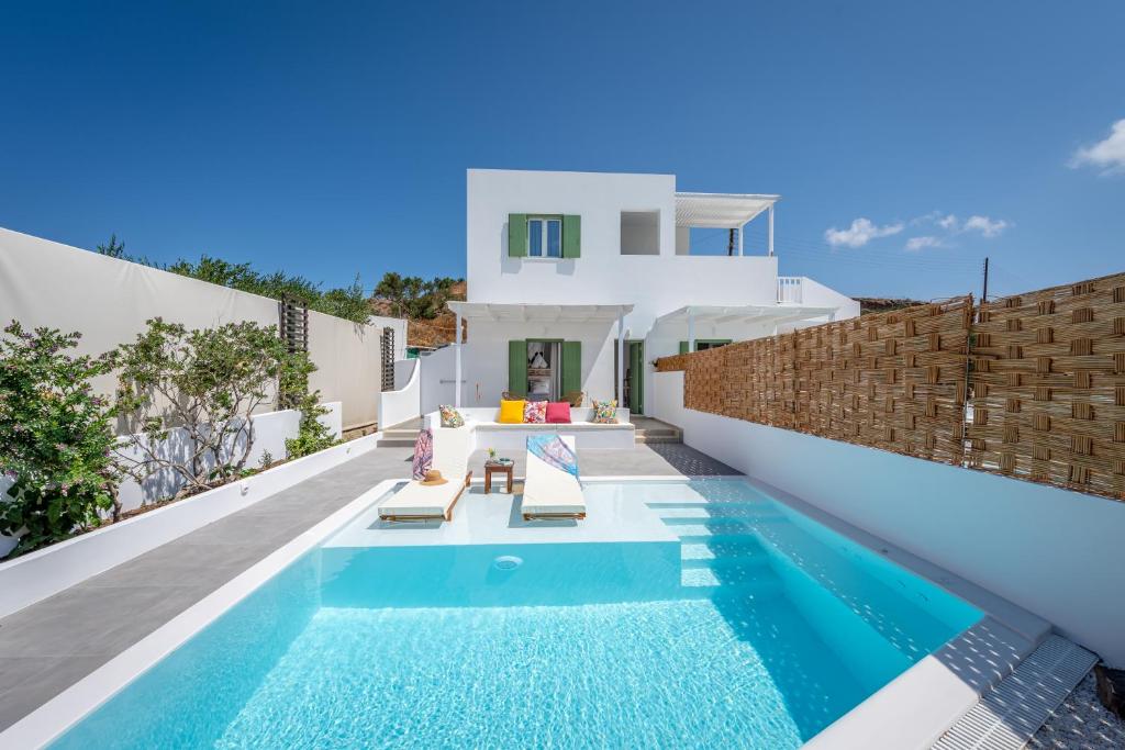 a villa with a swimming pool and a house at Terra Oliva Milos in Pollonia
