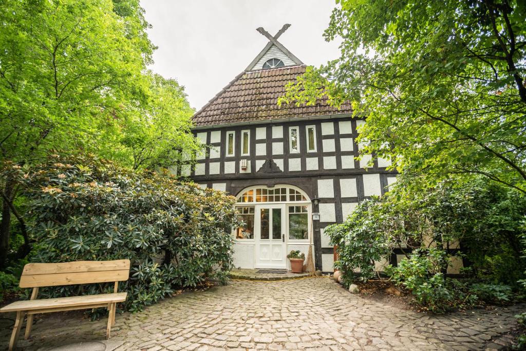 une maison noire et blanche avec un banc devant elle dans l'établissement Ferienwohnung Lieblingsplatz, à Brême