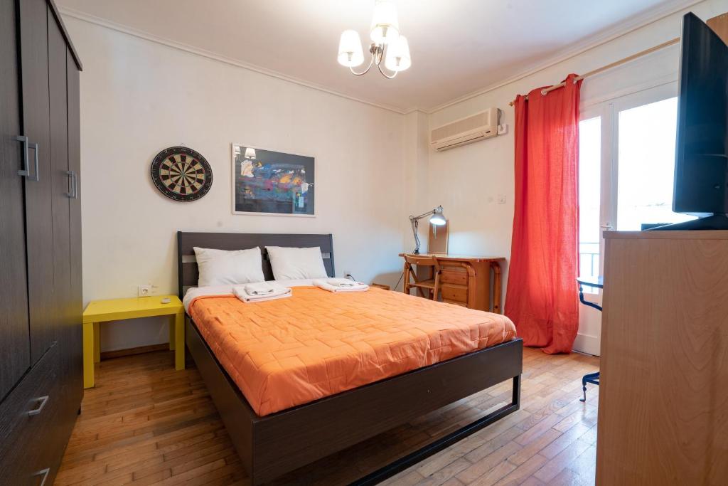 a bedroom with a bed with an orange bedspread at Zografou Apartment 1 bed 2 pers in Athens