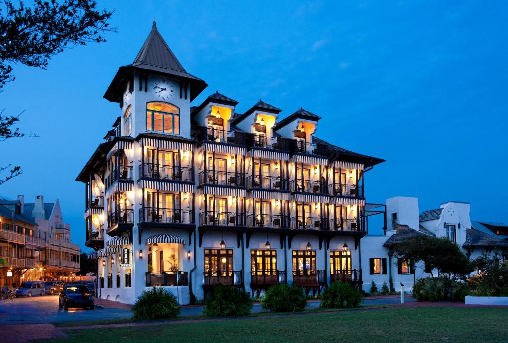 un grande edificio bianco con torre dell'orologio di notte di The Pearl Hotel a Rosemary Beach