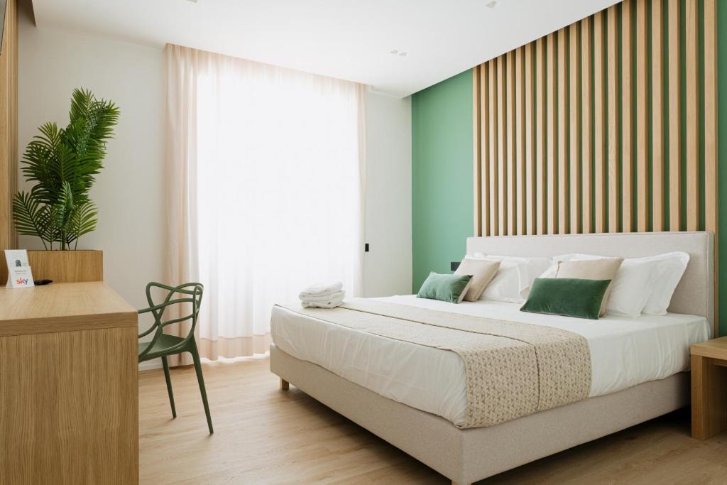 a bedroom with a large white bed and a desk at Plana Hotel in Caserta