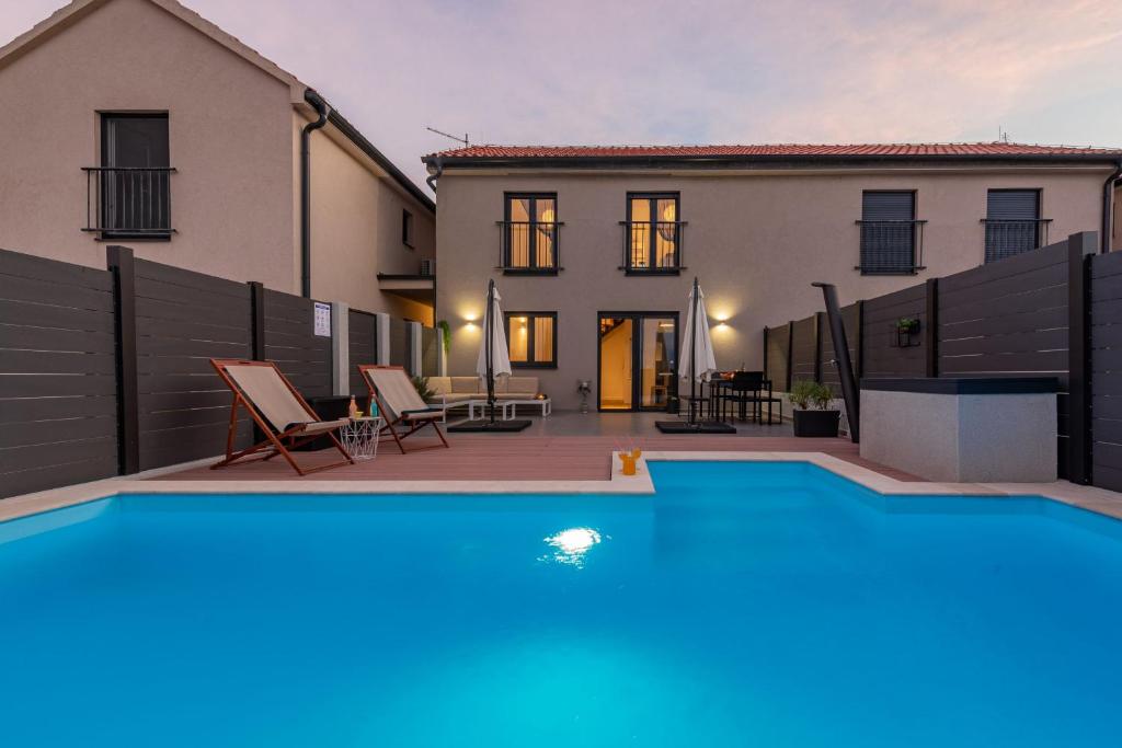 a villa with a swimming pool in front of a house at Villa NiA ZadarVillas in Nin