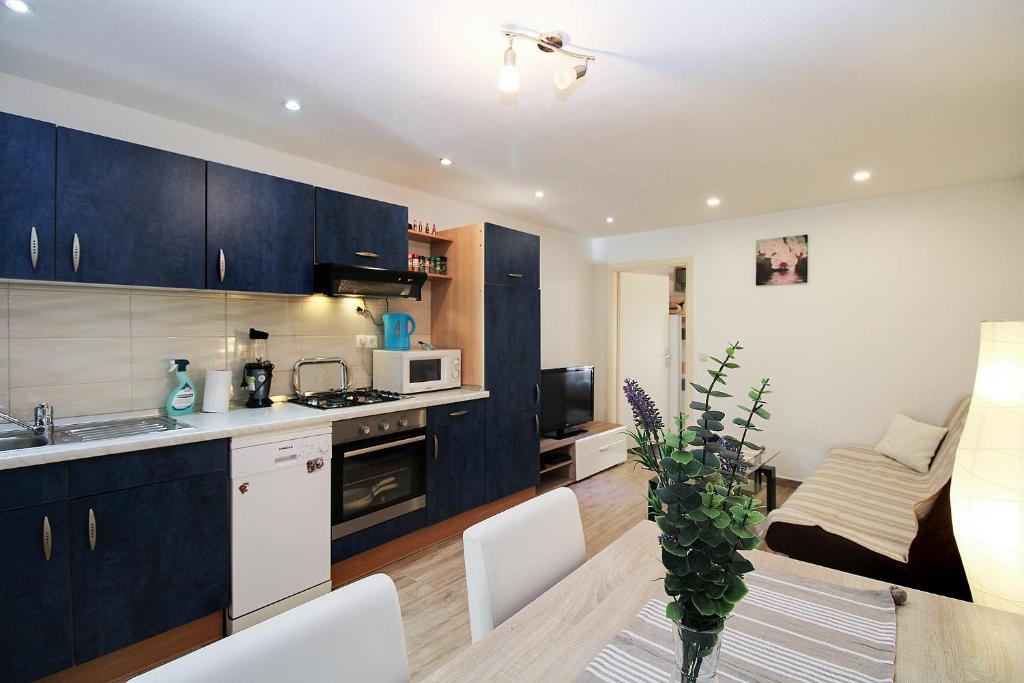 a kitchen with black cabinets and a table with chairs at Apartment Besima 2178 in Pula