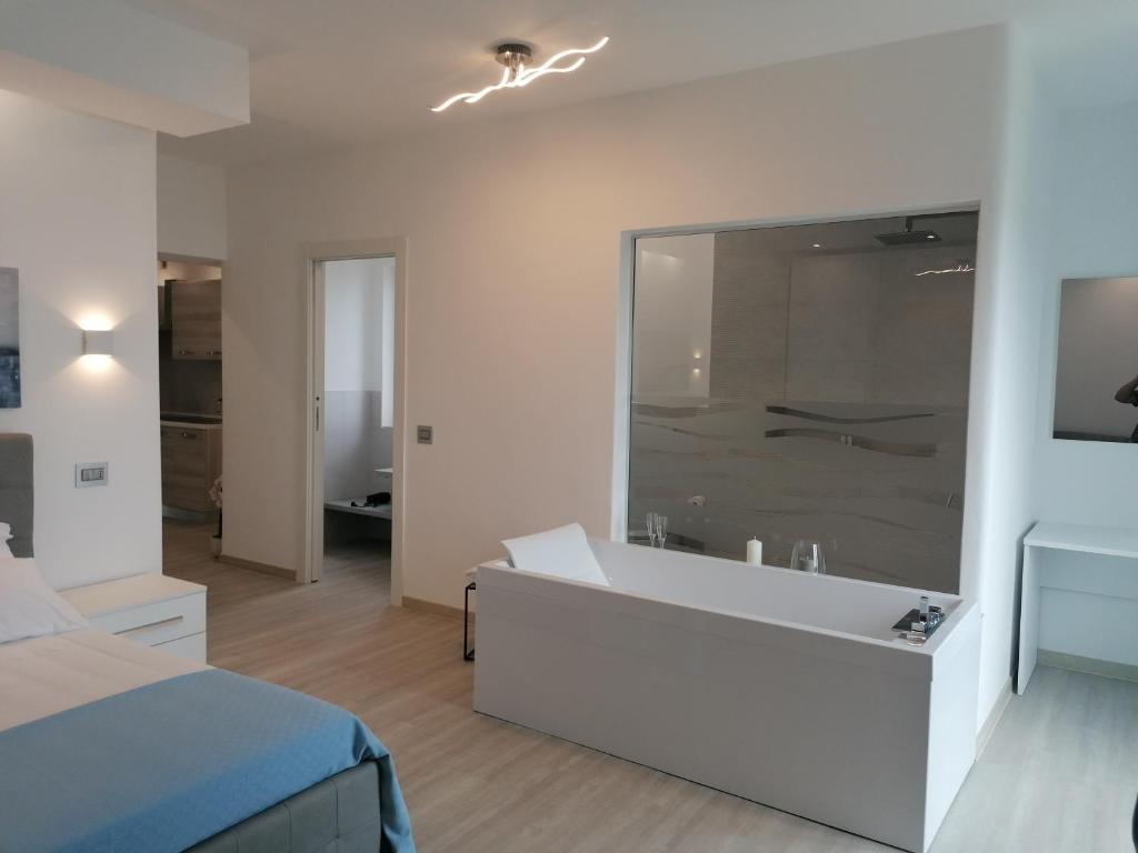 Biała łazienka z wanną i sypialnia w obiekcie Borgonuovo Luxury Home w mieście Peschici