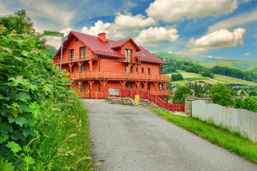 a large wooden house on the side of a road at Apartamenty Soszów in Wisła