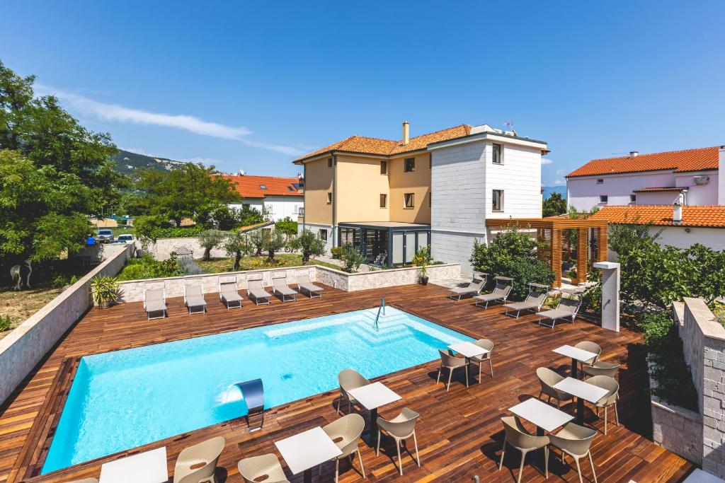 uma piscina num deque de madeira ao lado de uma casa em Vila Iris Baška em Baška