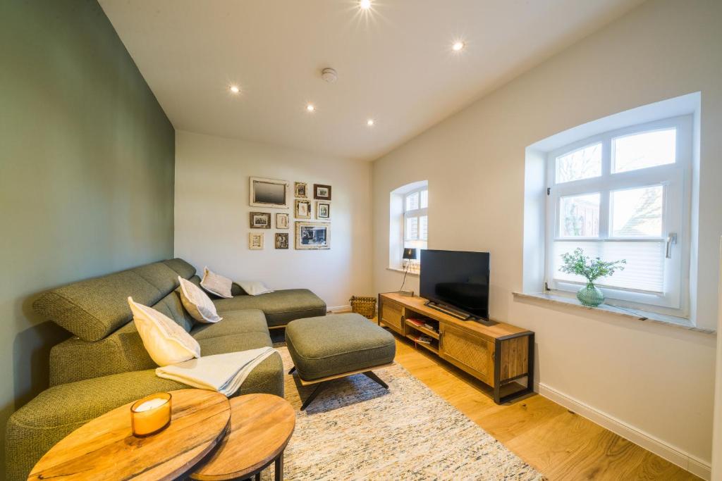 a living room with a couch and a tv at Leuchtturmhaus 1888 EG Wohnung in Borkum