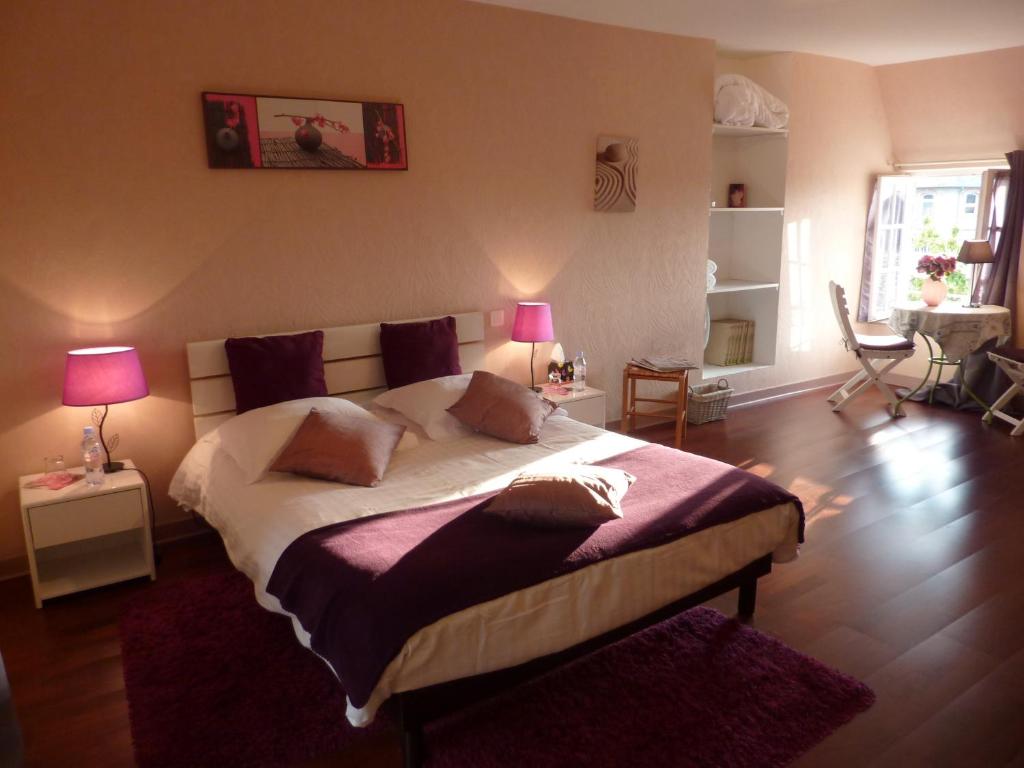 - une chambre avec un grand lit et deux lampes dans l'établissement Maison d'Hôtes Les Belles de Mai, à Pontorson