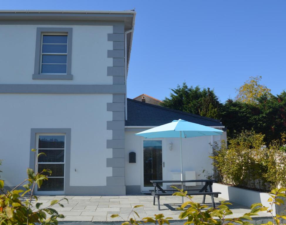 a table and an umbrella in front of a house at Modern home close to town Free Parking, Free Wifi, Dogs Allowed, Torquay, Sleeps Four in Torquay