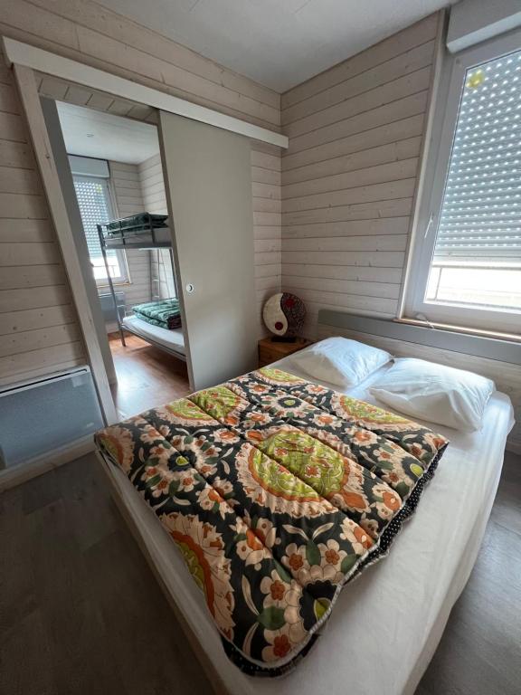 a bedroom with a bed with a quilt on it at APPARTEMENT 4 PERSONNES CLASSE 2 ETOILES LEBOUCQ Laurent in Fort-Mahon-Plage
