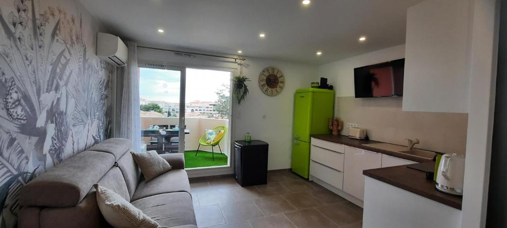 un salon avec un canapé et une cuisine dans l'établissement Charmant Studio Sète cosy Refait à neuf Parking Plage à pied, à Sète