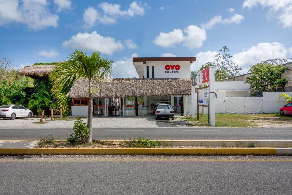 una tienda con una palmera frente a una calle en OYO Hotel Palma Real, en Tulum