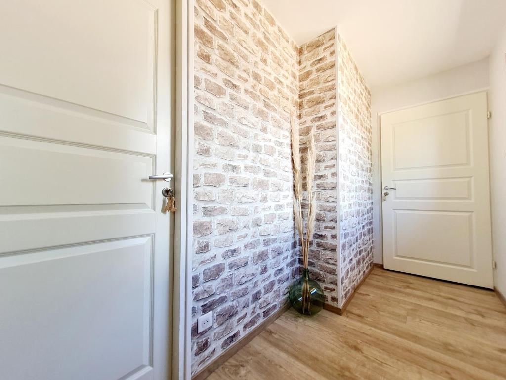 un pasillo con una pared de ladrillo y una puerta en Chambres d'hôtes La Ganivelle, en Servant