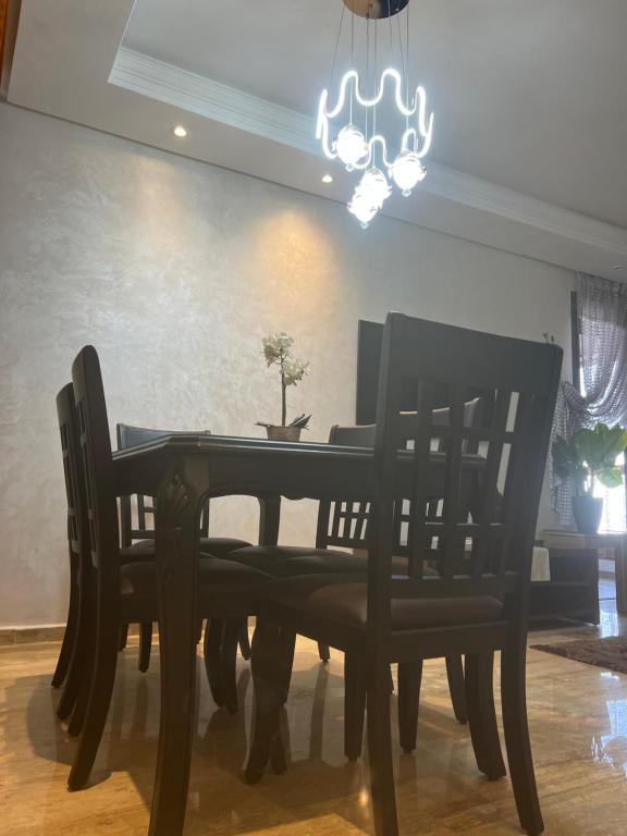 een eettafel met stoelen en een kroonluchter bij luxury apartments in Casablanca