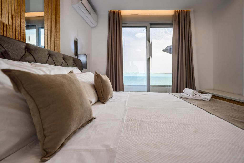 a bedroom with a large bed with a view of the ocean at G Star Hotel in Sutomore