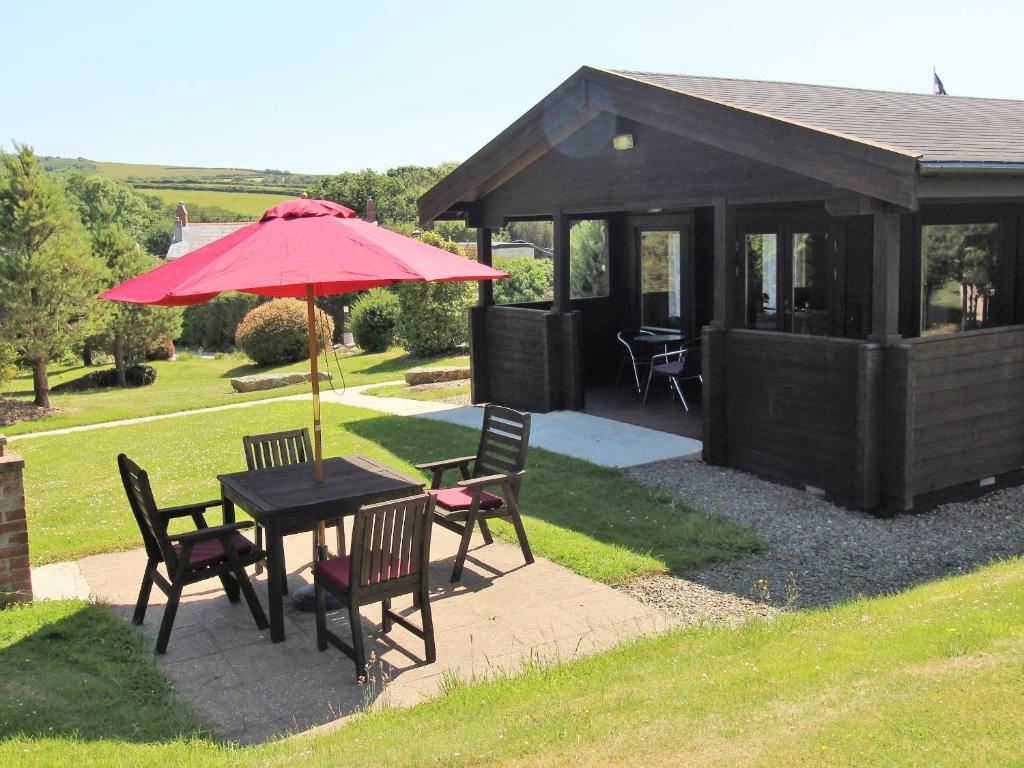 a table and chairs with an umbrella and a gazebo at Hazel Lodge in Bodmin