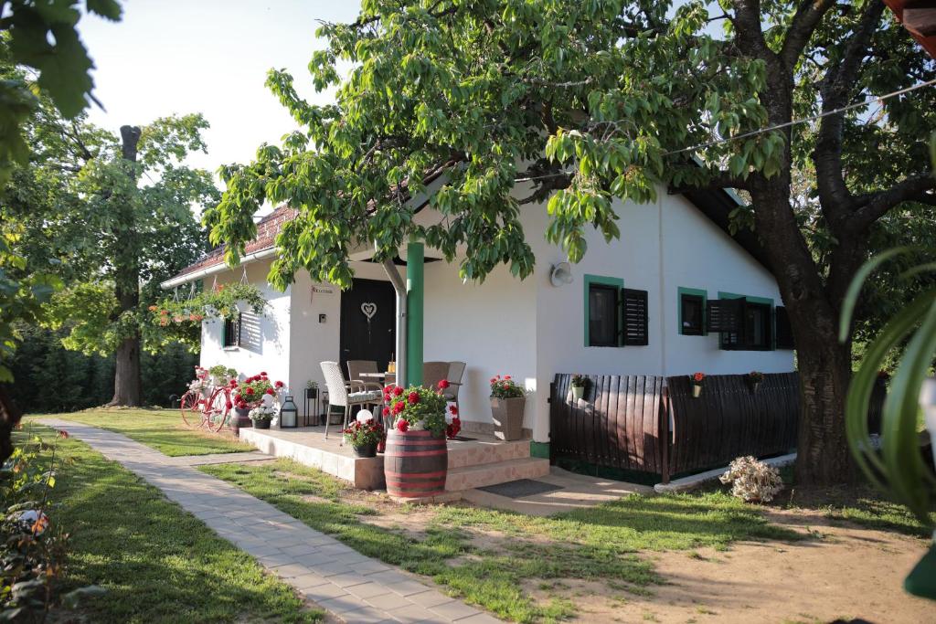 Una casa blanca con un árbol delante. en Apartment Amigo en Sirova Katalena