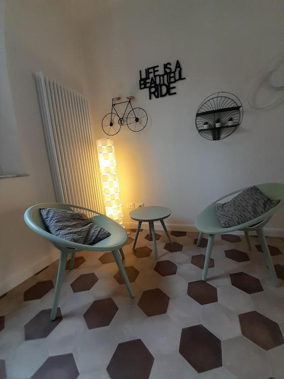 Pokój z dwoma krzesłami i stołami oraz rowerem na ścianie w obiekcie B&B Villino Luschi Pisa Centro w Pizie