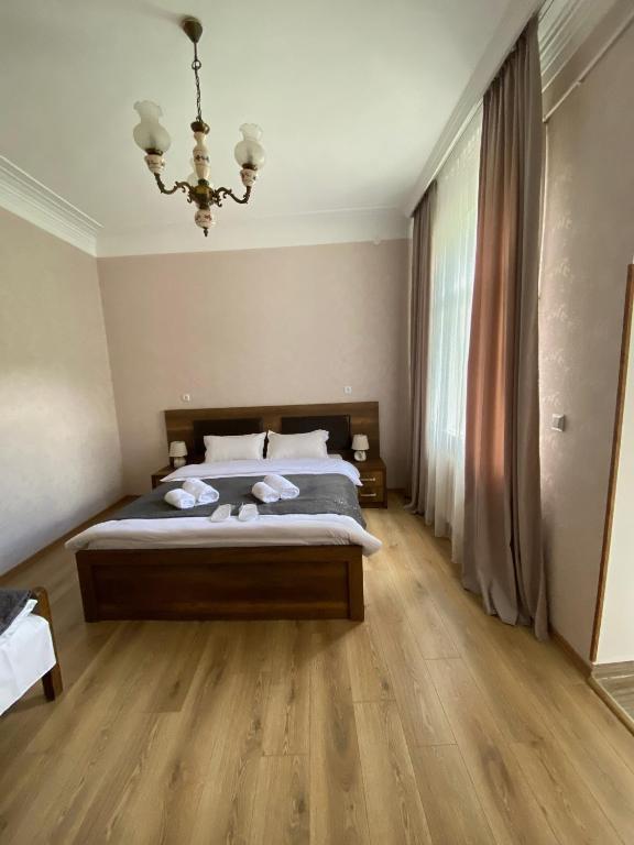 a bedroom with a bed and a chandelier at Dato Khetaguri Apartment in Kazbegi