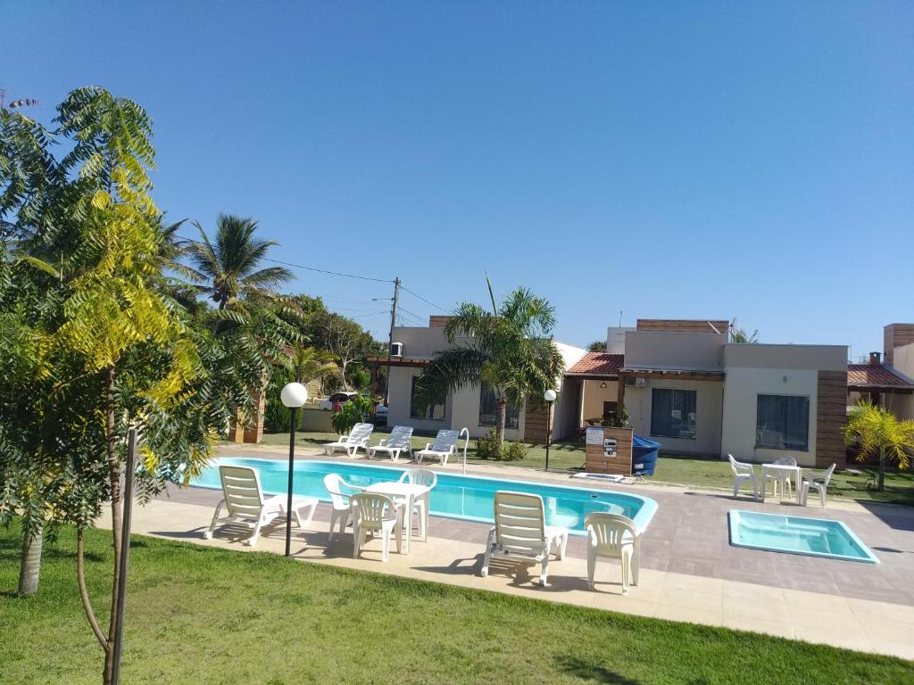 uma villa com uma piscina e uma casa em Vila Axé Flat 05 Riviera em Prado