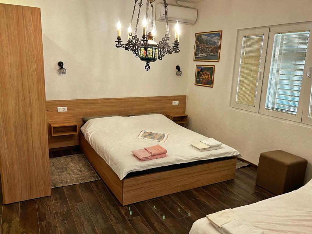 - une chambre avec un lit et un lustre dans l'établissement Apartment Dimeski, à Ohrid