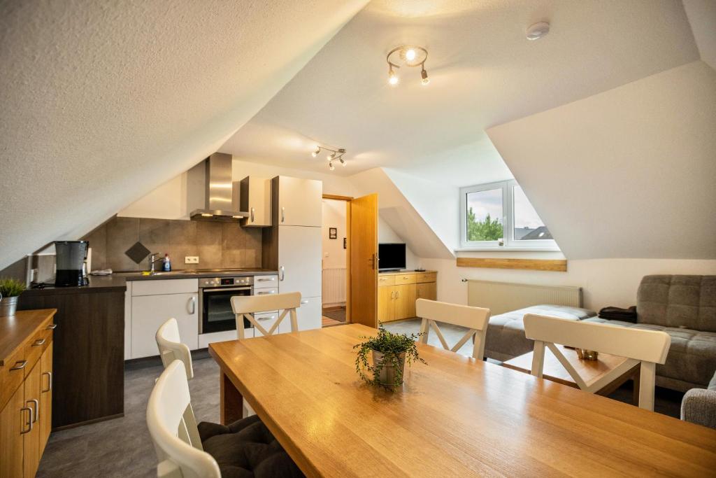 a kitchen and living room with a table and chairs at Nordsee Ferienwohnung Möwe in Thunum