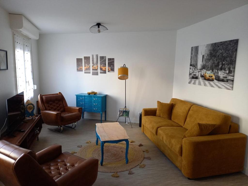 a living room with a couch and chairs and a table at Appart plein centre, balcon, 4 personnes in Sedan