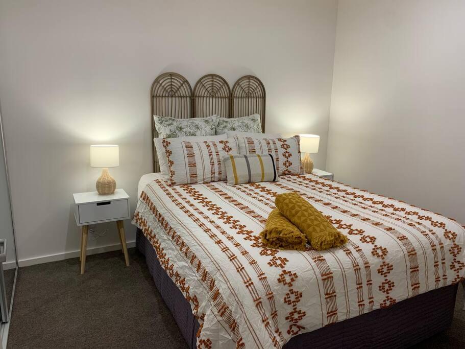 een slaapkamer met een groot bed en 2 lampen bij Plush at Dawn, Canberra city in Canberra