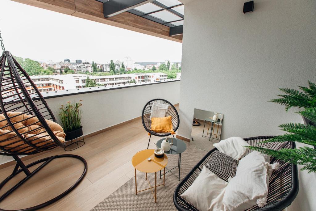 a living room with two chairs and a balcony at Stan na dan - Chic Home Banja Luka in Banja Luka