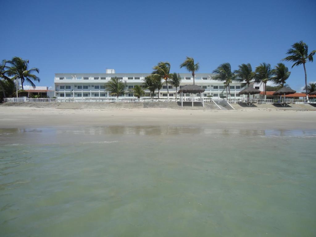 uma vista para a praia com um hotel ao fundo em Marinas de Tamandaré 102 em Tamandaré