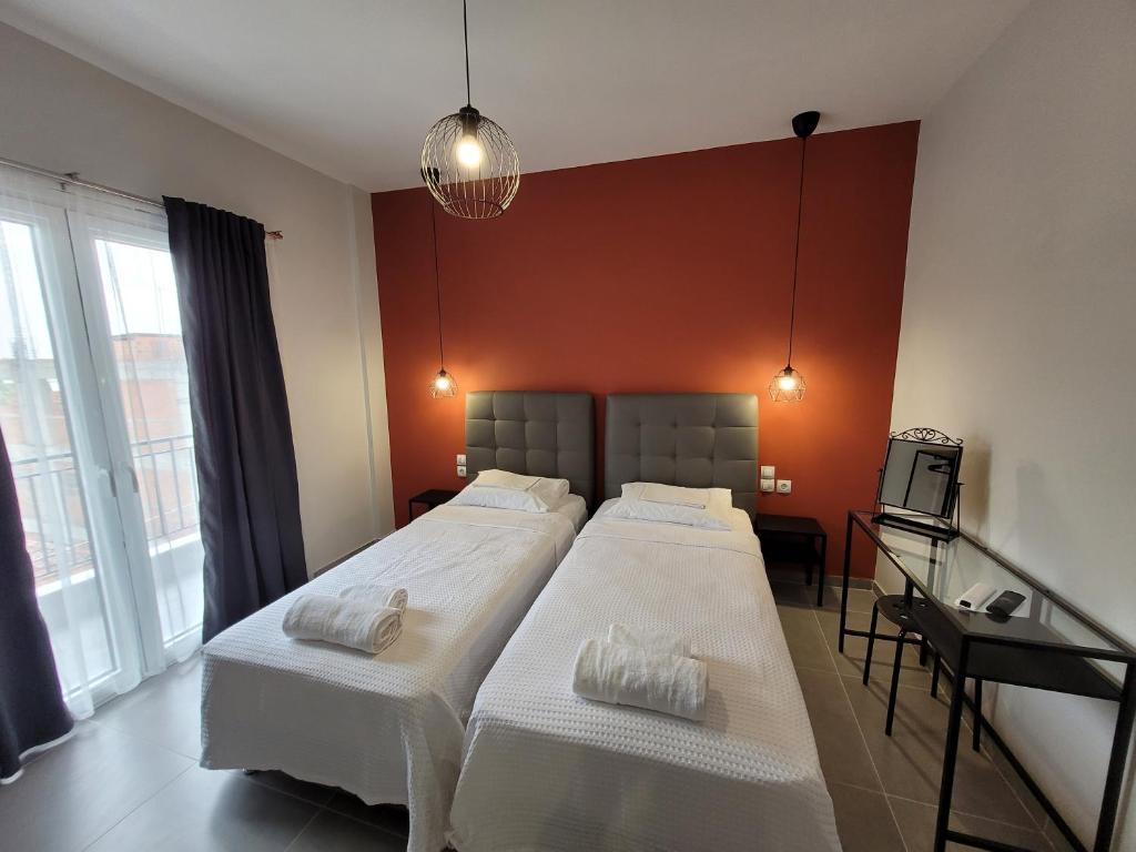 een slaapkamer met 2 bedden en een rode muur bij LA CASA DE PROFESOR 2 in Kalabaka