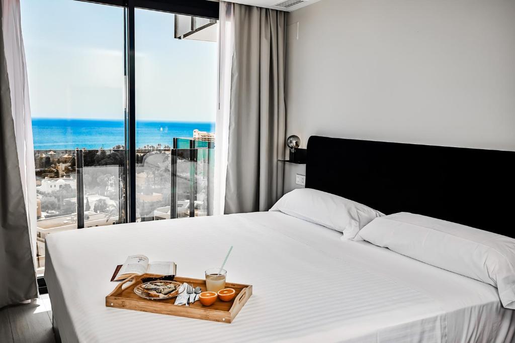 a bedroom with a bed with a tray of food on it at HO Aguadulce in Aguadulce