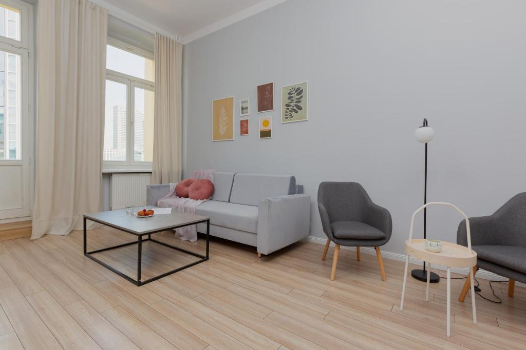 a living room with a couch and a table at Apartments Aleje Jerozolimskie 85 by Renters in Warsaw