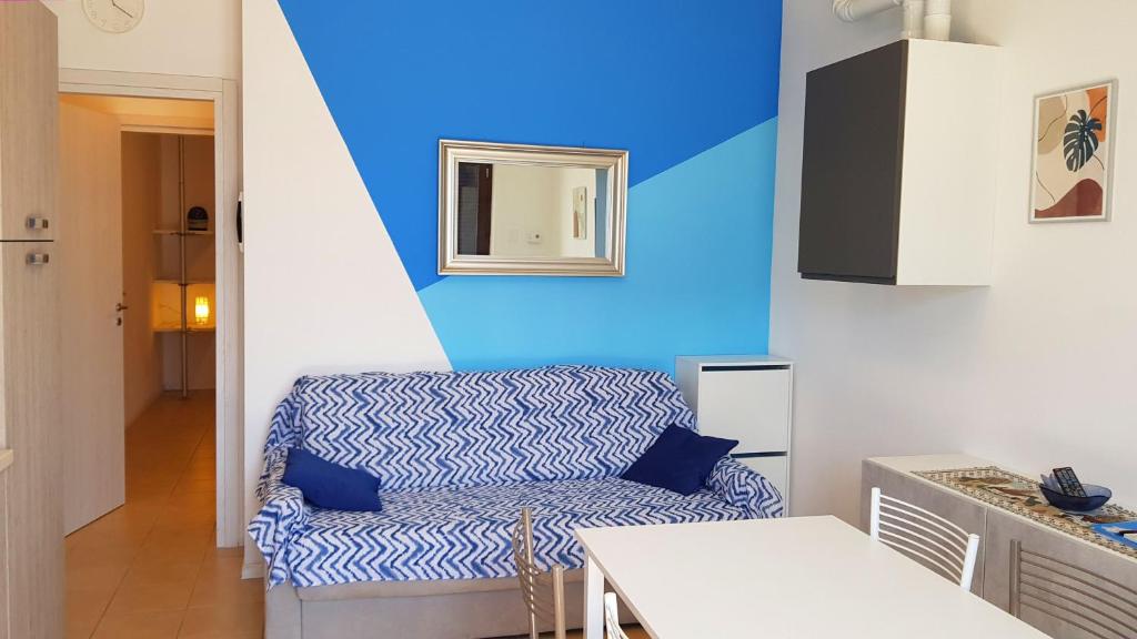 a living room with a couch and a blue wall at La Quiete 08 lake view Apartment By Garda Domus Mea in Tremosine Sul Garda