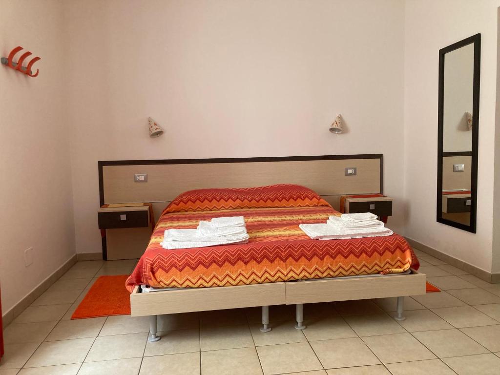una camera da letto con un letto con una coperta rossa e uno specchio di Solìa Bed & Breakfast a Scalea