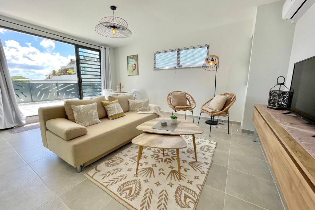 a living room with a couch and a table at Mereani flat brand new condo in the center of Papeete in Papeete