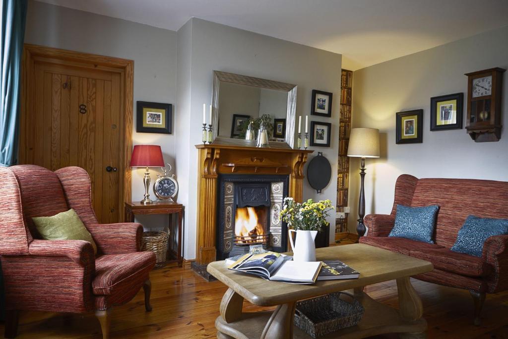 a living room with a fireplace and two chairs and a table at Cullinan's Guesthouse in Doolin