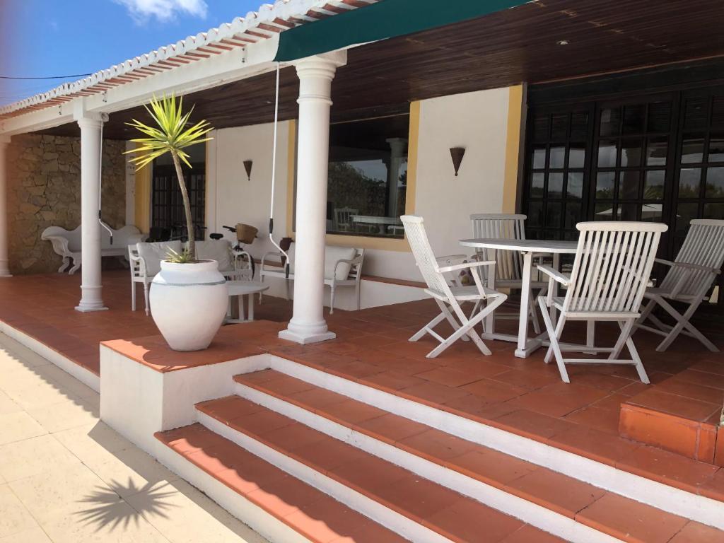 a patio with white chairs and tables on a house at Vinha da Quinta in Sintra