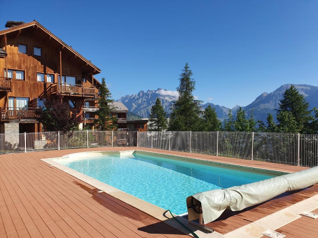 uma piscina em frente a uma casa em Appartement T3 neuf au frais à la montagne em Puy-Saint-Vincent