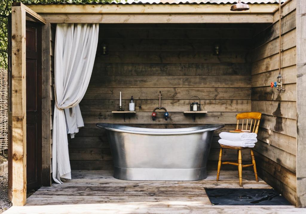 a bathroom with a tub and a sink at The Workers Cottage in Great Bircham