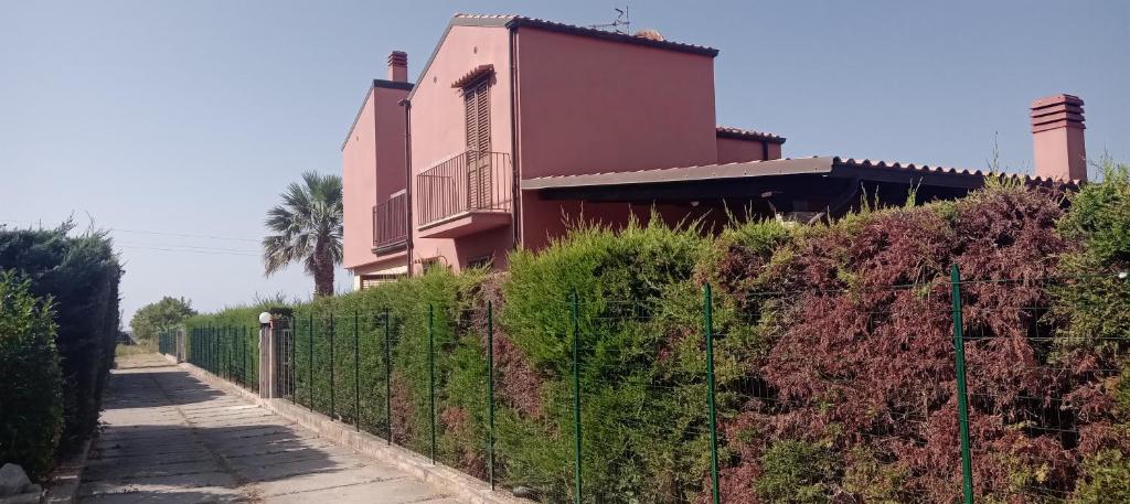 a fence in front of a house with a building at SeFloNia in Lascari