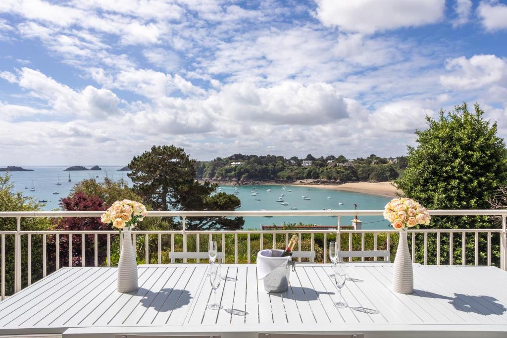 uma mesa com dois vasos com flores numa varanda em KER MANOU - Baie des dauphins em Cancale