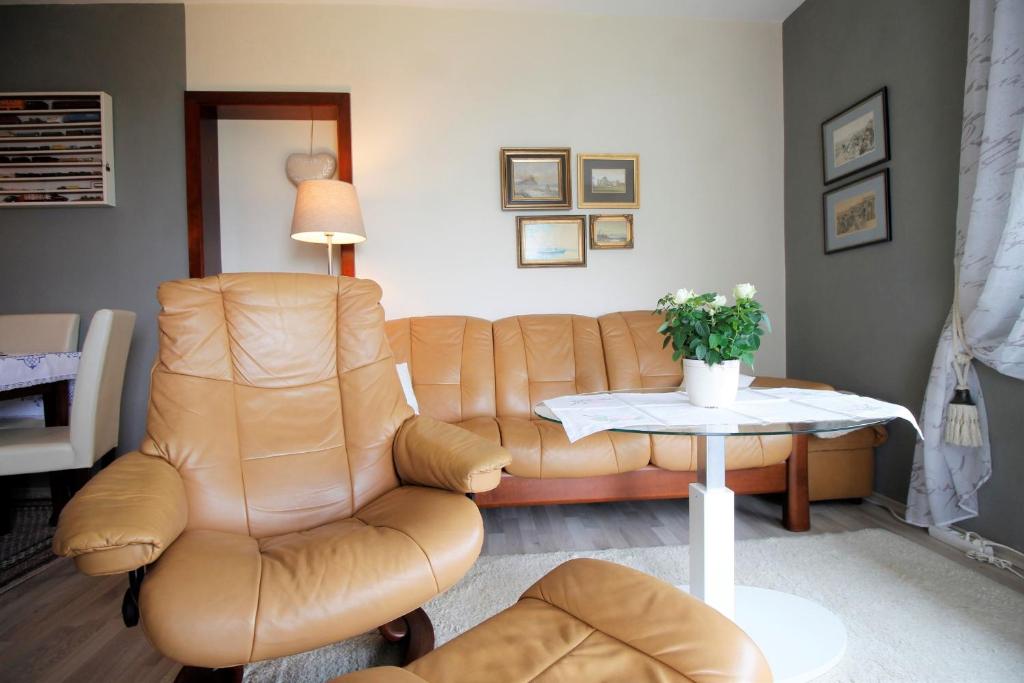sala de estar con sofá de cuero y mesa en Hanseat I - Whg 71 - Top Lage mit Seeblick und WLAN, en Grömitz